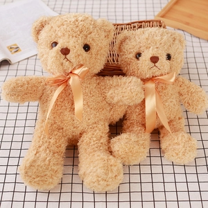 Detail of plush teddy bear skin with golden ribbon on black and white checkered cloth