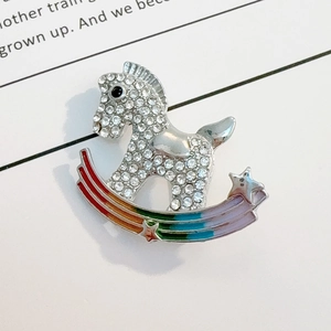 Detailed close-up of crystal-inlaid rocking horse brooch with rainbow enamel finish
