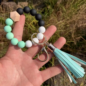Detail of beaded keychain bracelet with mint green silicone beads and hexagon wood bead