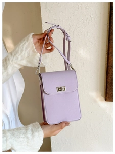 Detail of light purple Saffiano crossbody bag with silver twist lock held by hand