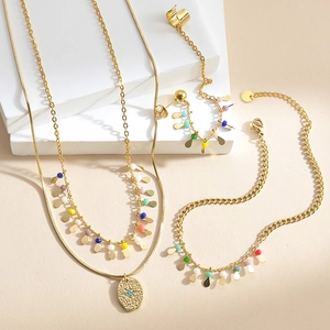 Close-up of gold double-layer necklace, bracelet and earrings with colorful beads