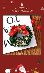 Detail of mini star Christmas wreath with golden bells, red ribbon and Merry Christmas sign