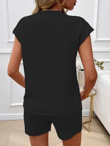 Back view of black two-piece set featuring sleeveless top and shorts in home setting