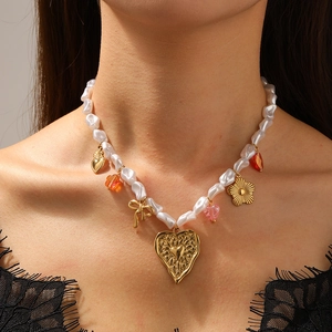 Faux pearl necklace with gold heart pendant and colorful beads on a female model