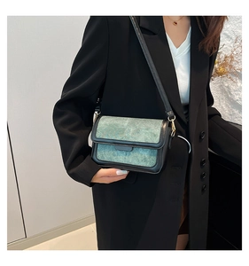 Detail of teal marble texture small square bag with black strap and metal buckle