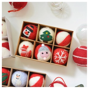 Close-up of handmade wool felt Christmas ornaments with embroidery in a kraft gift box