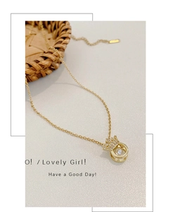 Detail of gold crown necklace with dancing stone and pavé zircon on white background