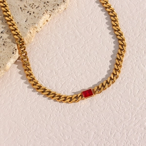Detailed view of gold Cuban chain necklace with a centered red rectangular zircon gem