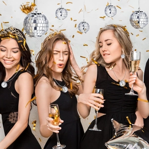 Models wearing silver disco ball necklaces and earrings in a festive party setting with confetti
