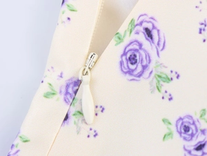 Détail macro de la fermeture éclair invisible sur une robe en satin à fleurs crème