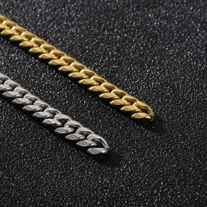 Detailed close-up of gold and silver Cuban link bracelets with metallic luster