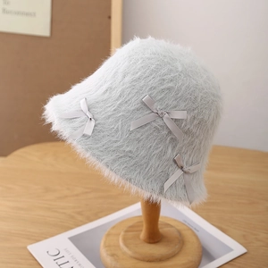 Detail of grey plush bucket hat showing faux rabbit fur texture and ribbon bows