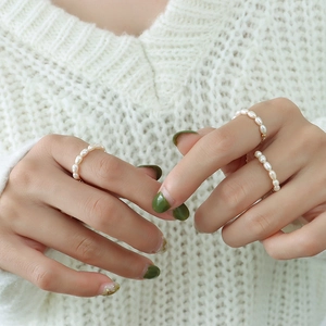 Bague ajustable en perles d'eau douce élégante avec détails dorés sur modèle