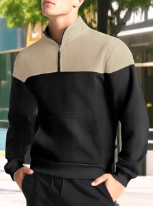 Detail of men's half-zip hoodie featuring khaki and black panels with quilted texture
