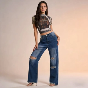 Detail of high-waisted distressed jeans with large knee rips and vintage blue wash finish
