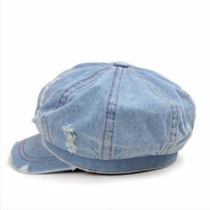 Detailed view of the distressed light blue denim newsboy cap with vintage washed texture