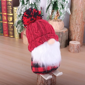 Christmas gnome doll with red knitted hat and plaid body on wooden skis decoration