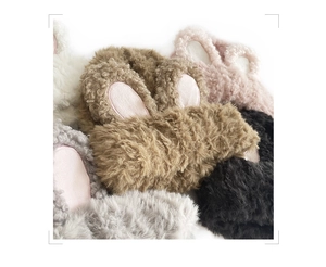 Close-up of plush rabbit ear headbands in various colors including brown, pink and grey