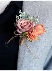 Detail of handmade groom boutonniere with silk rose and twine on grey wool suit lapel