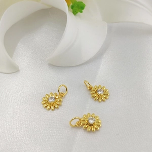 Golden 14K gold-plated daisy flower pendants with sparkling cubic zirconia on white silk