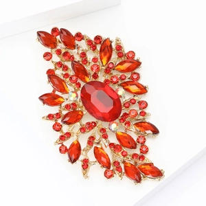 Vintage gold alloy brooch with large red glass crystal on a clean white backdrop