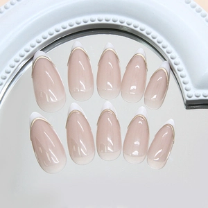 French almond press-on nails with white tips and delicate gold trim on glossy pink base