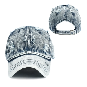 Close-up of distressed vintage denim baseball cap with worn holes and metal buckle