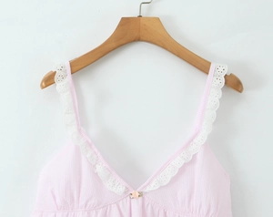 Detail of pink striped camisole top featuring delicate white lace trim and rose ornament