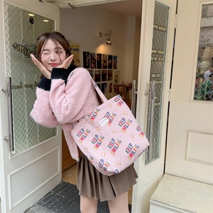 Close-up of pink corduroy tote bag featuring colorful Keep Smiling face print