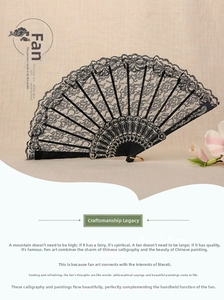 Detailed close-up of a black lace folding fan with floral patterns and a metal ring accessory