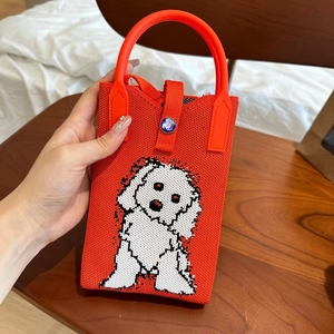 Détail du sac de téléphone en tricot orange avec motif de chiot blanc mignon