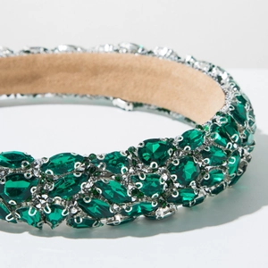 Macro detail of luxury baroque headband with emerald green crystals on silver base