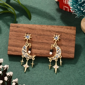 Star and moon gold plated tassel earrings with blue cubic zirconia on Christmas background