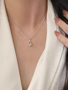 Close-up of minimalist solid S925 sterling silver teardrop pendant on a sleek snake chain