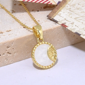 Golden necklace with circular white shell pendant featuring sunburst metal detailing