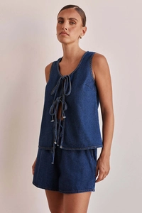 Detail view of denim two-piece set featuring lace-up sleeveless top and high-waisted shorts