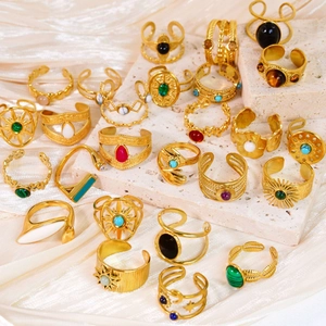 Vintage 14k gold plated stainless steel rings with assorted colorful gemstones on stone
