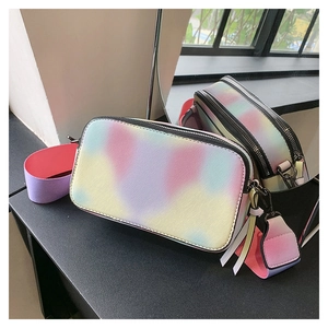 Detail of gradient tie-dye crossbody camera bag with cross-grain texture and wide strap