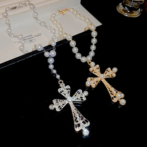 Detail of diamond and pearl hollow cross pendants in gold and silver plating