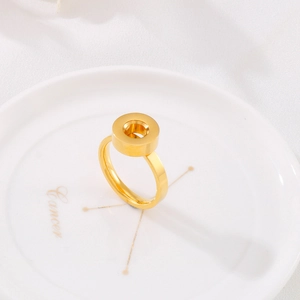 Close-up of a gold stainless steel hollow disc ring placed on a decorative white plate