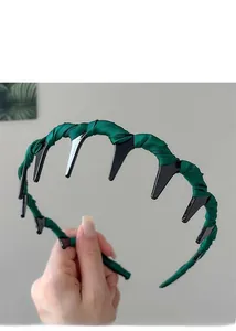 Close-up of dark green pleated fabric headband with black wide-toothed inner comb grip