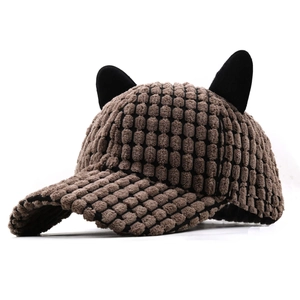 Brown corduroy baseball cap with black cat ears and warm fleece texture on white background