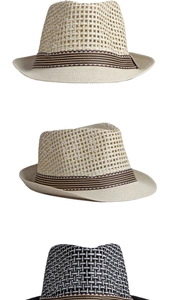 Dettaglio di tre cappelli trilby intrecciati in beige e nero con nastri a righe