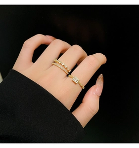 Detail of gold double-layer diamond rings and square zircon ring worn on fingers