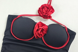 Détail de la décoration rose rouge sur une robe courte sexy dos nu bicolore noire et rouge