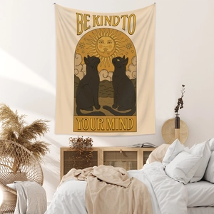 Detail of bohemian tapestry featuring black cats, sun and Be Kind To Your Mind slogan