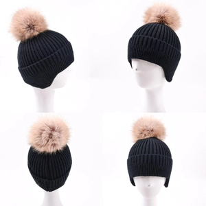 Black knit earflap beanie with faux fur pompom shown from multiple viewing angles