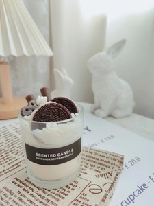 Detail of soy wax candle featuring realistic chocolate biscuit and wafer toppers in glass cup