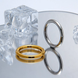 Minimalist 2.5mm gold and silver titanium steel rings displayed on creative ice cubes