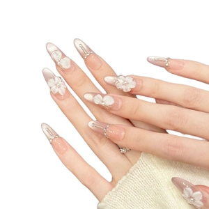 Pink gradient almond press-on nails with 3D floral petals, pearls, and crystals